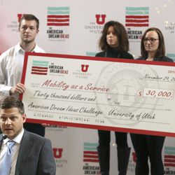 Blake Perez and members of Mobility as a Service accept a check for being one of three finalists in the American Dream Ideas Challenge during ceremony at the University of Utah in Salt Lake City on Thursday, Nov. 29, 2018.