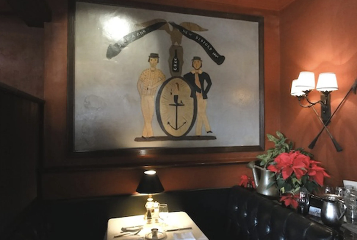 An old painting hangs on a wall in a bar. 