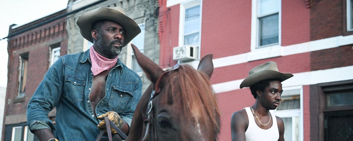Idris Elba as Harp and Caleb McLaughlin as Cole riding horses in Concrete Cowboy
