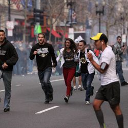 In this photo provided by The Daily Free Press and Kenshin Okubo, people react to an explosion at the 2013 Boston Marathon in Boston, Monday, April 15, 2013. Two explosions shattered the euphoria of the Boston Marathon finish line on Monday, sending authorities out on the course to carry off the injured while the stragglers were rerouted away from the smoking site of the blasts.