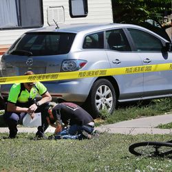 A Salt Lake police officer talks to a person at the scene of a shooting at 757 W. 200 North in Salt Lake City on Tuesday, Aug. 15, 2017. Police say a suspect was taken into custody at 800 North and North Temple.