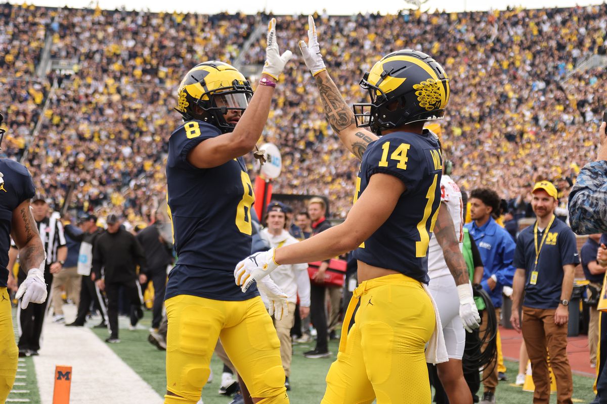 Roman Wilson #14 of the Michigan Wolverines celebrates his fourth quarter touchdown with Ronnie Bell #8 while playing the Maryland Terrapins at Michigan Stadium on September 24, 2022 in Ann Arbor, Michigan. Michigan won the game 34-27.