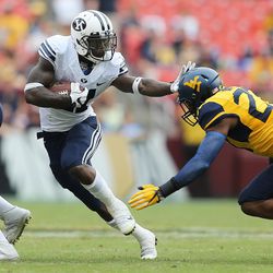 Brigham Young Cougars running back Jamaal Williams (21) stiff-arms West Virginia Mountaineers linebacker Sean Walters (27) during play at FedEx Field in Landover, Maryland on Saturday, Sept. 24, 2016.