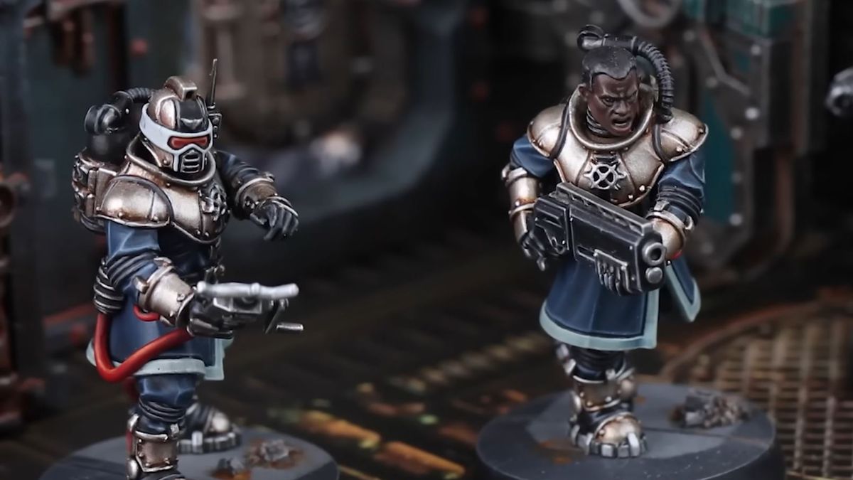 Two Imperial Navy Breachers run through the Gallowdark, one with a shotgun and another with a control console for a robotic ally.