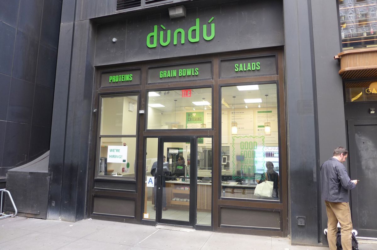 A black facade with green lettering up high.