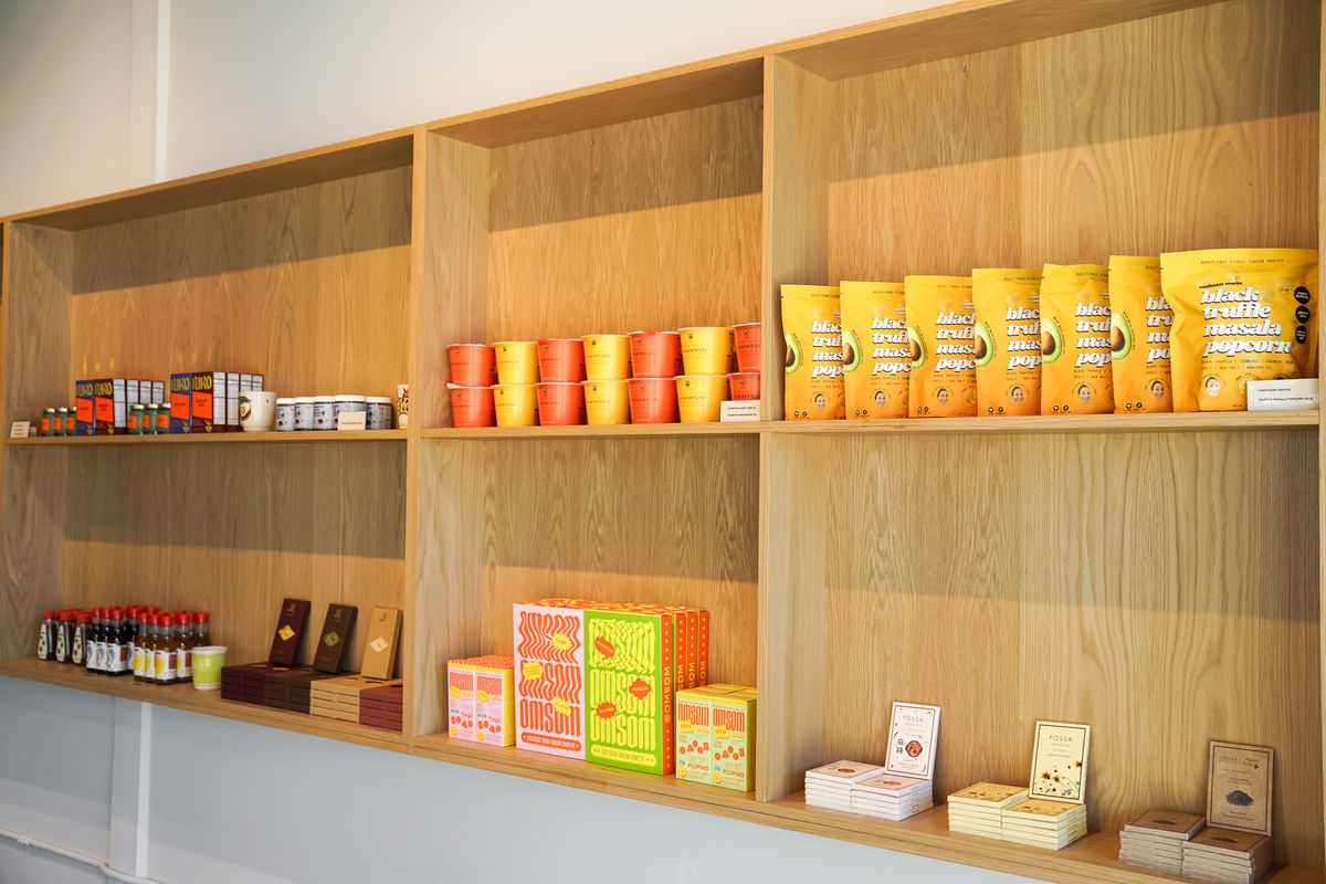 Retail shelves with cookbooks, chocolates, and cup ramen.