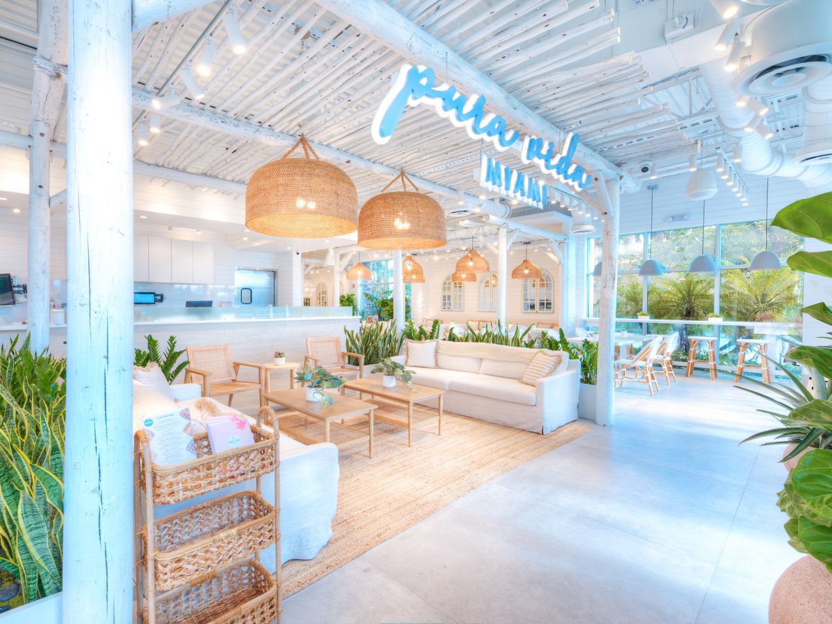 This is a picture of the restaurant space of Pura Vida in Wellington. The picture shows a white dining room with white sofas in the foreground with white dining tables in the background. It is a very light and airy space.