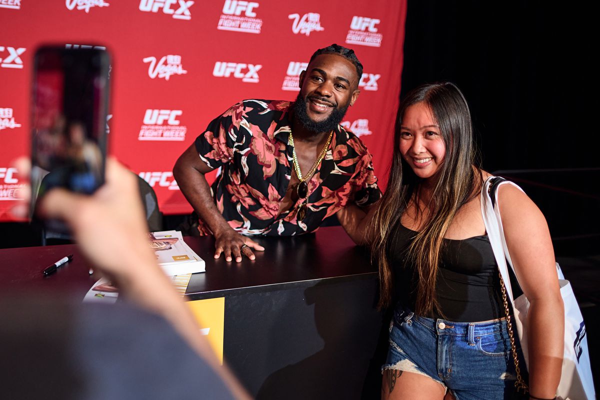 UFC champion Aljamain Sterling poses for a photo with a fan at UFC X 2022 in Las Vegas in July.