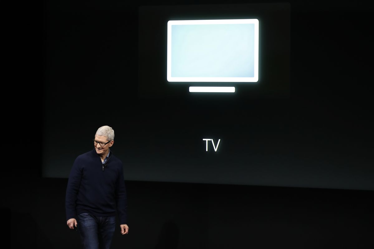 Apple CEO Tim Cook onstage in front of a TV icon.