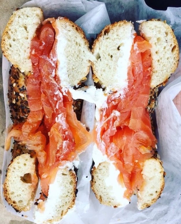 bagel with cream cheese and salmon split in two.