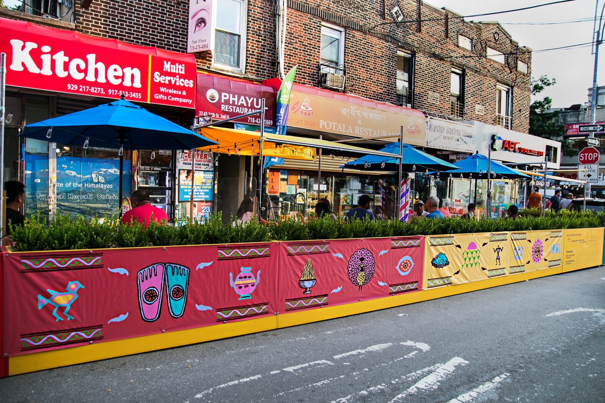 An exterior view of outdoor dining platforms built for restaurants during coronavirus. These brightly colored streeteries were designed by DineOut NYC. 