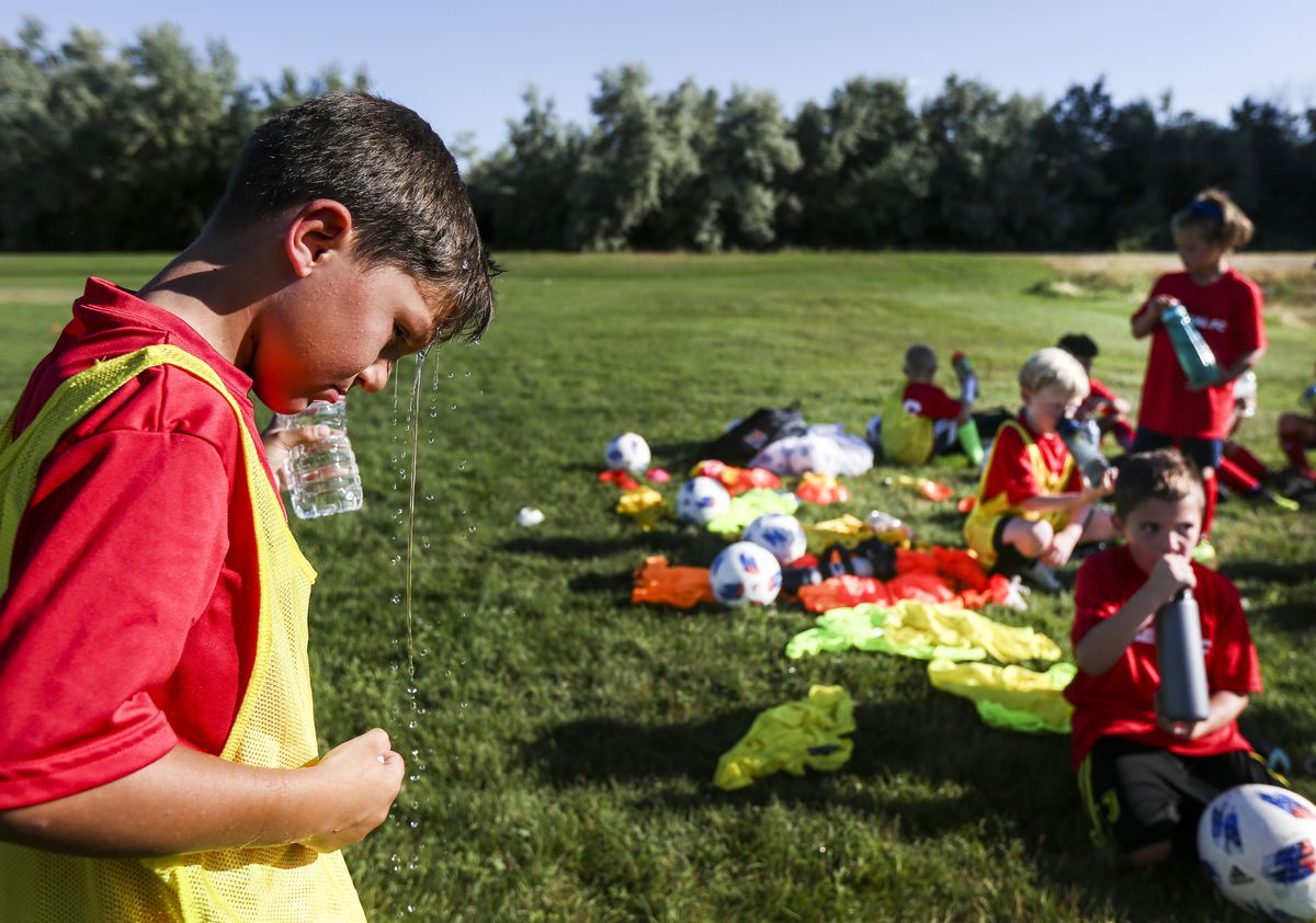 Anthony Armstrong, 9, pours water over his head to cool off while taking a water break during a practice at North Lake Park in Lehi on Thursday, Aug. 1, 2019.