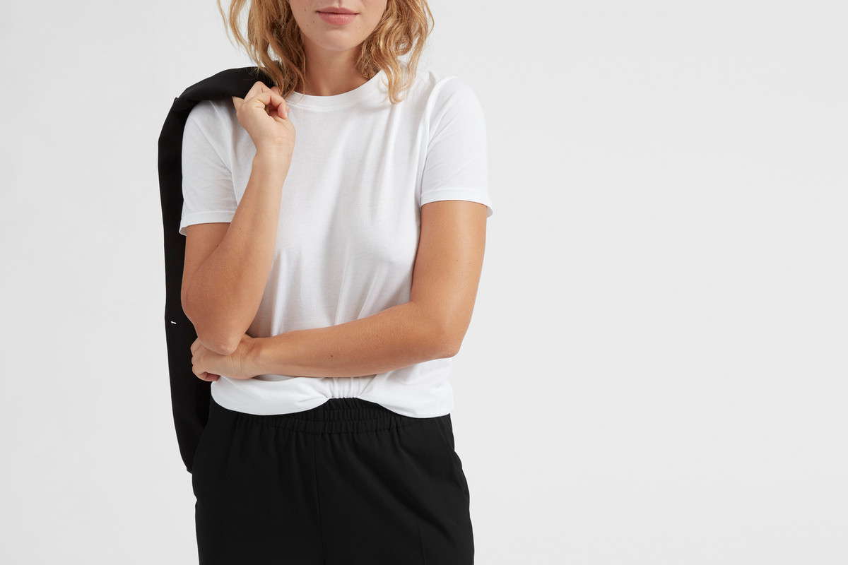 A model wearing black pants and a white tee