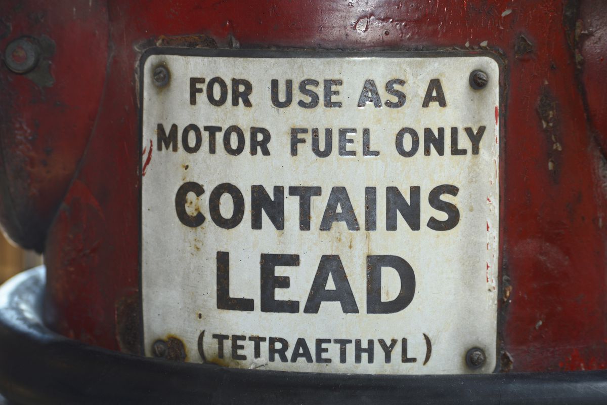 A sign on a vintage gasoline pump advises that the gas contains lead (tetraethyl).