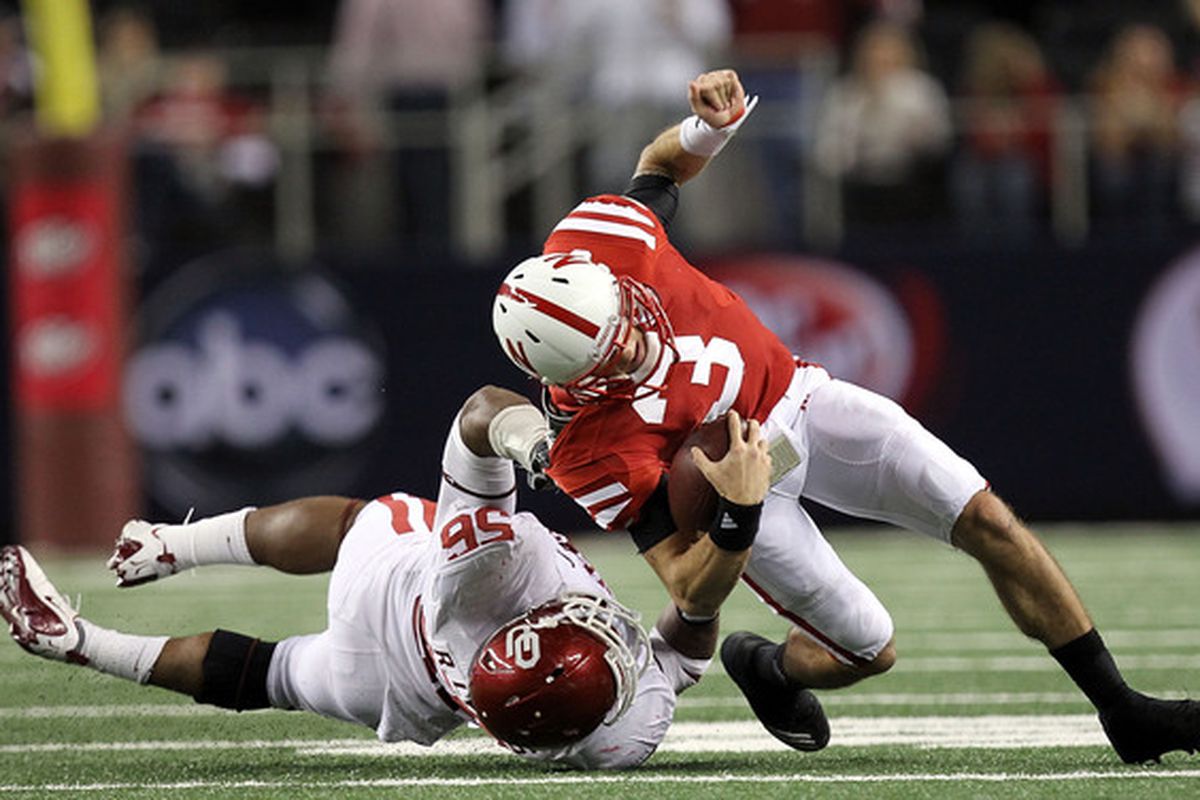 Quarterback Taylor Martinez #3 of the Nebraska Cornhuskers is tackled by Ronnell Lewis #56 of the Oklahoma Sooners.