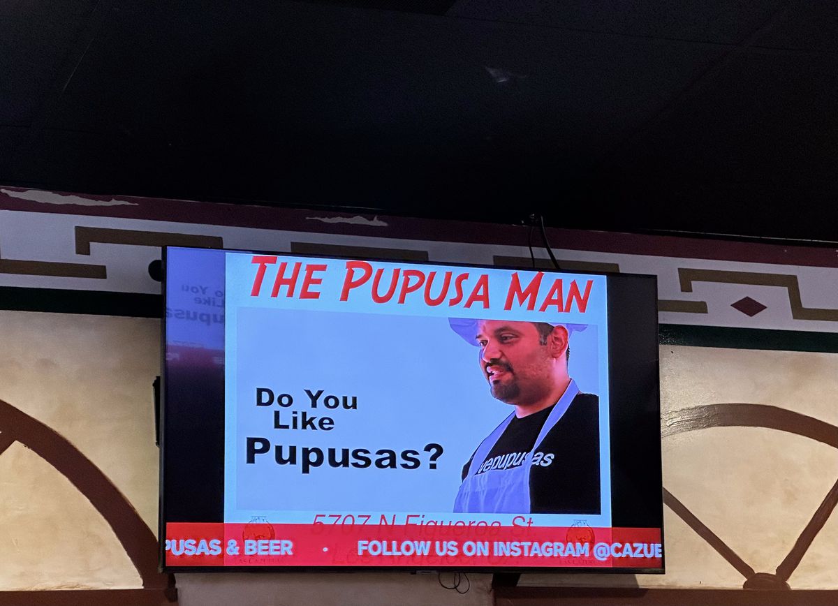 A television at Las Cazuelas showing a commercial of the Pupusa Man.