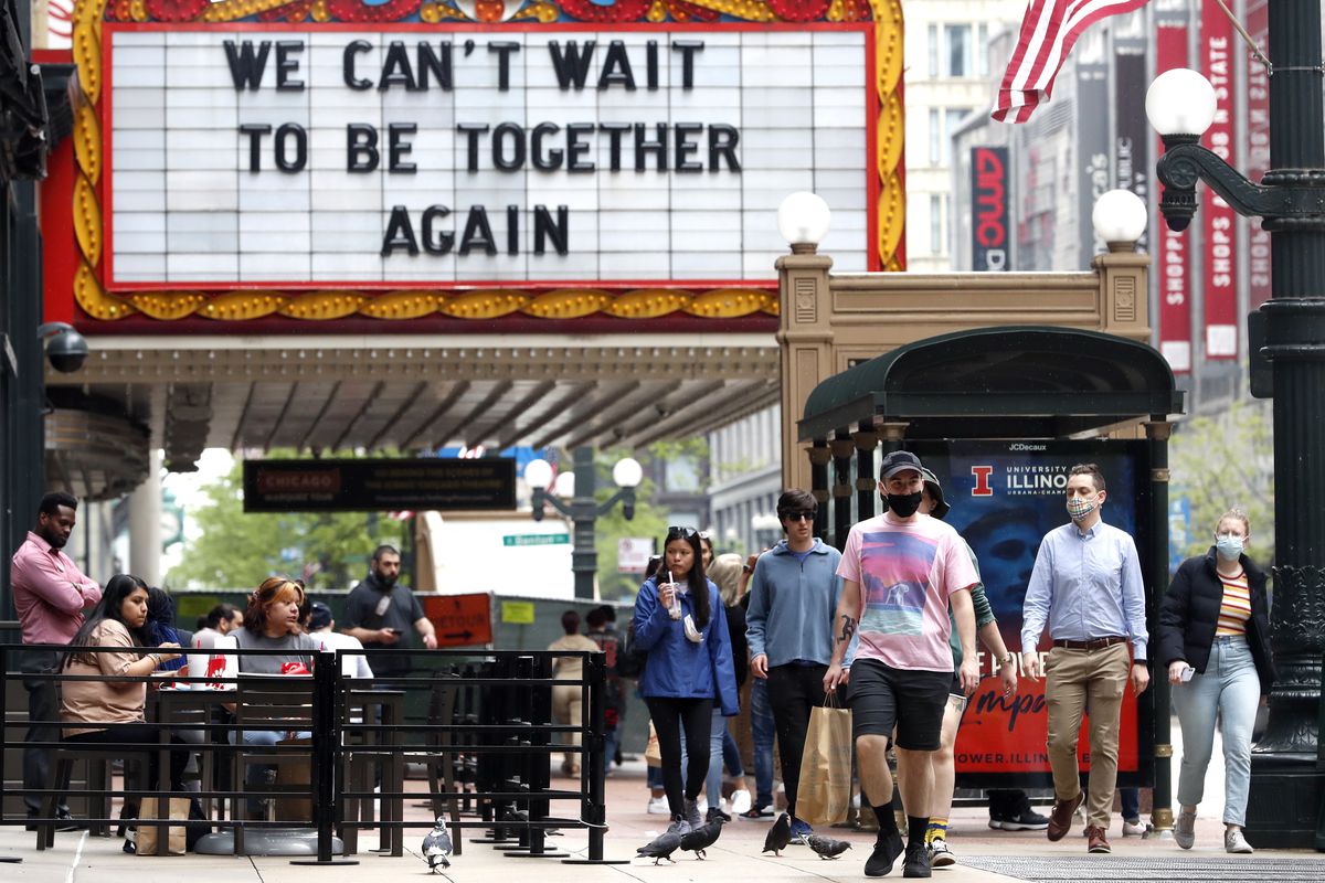 People walk near the Chicago Theatre, Tuesday, May 18, 2021 in Chicago’s famed Loop.