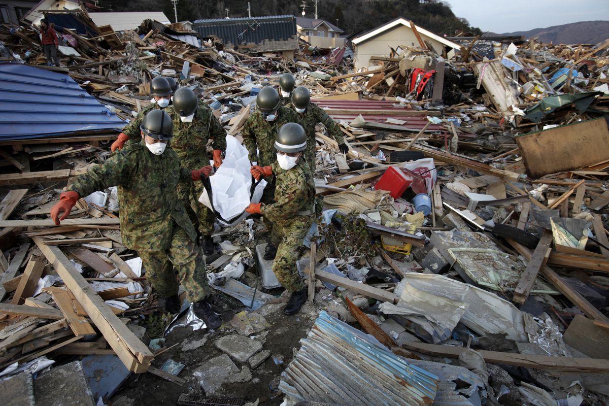 Self Defense Forces carry a body recovered from under a crushed house on April 1, 2011, in Ishinomaki, Miyagi, Japan, after a massive earthquake and tsunami hit northern Japan two weeks earlier.