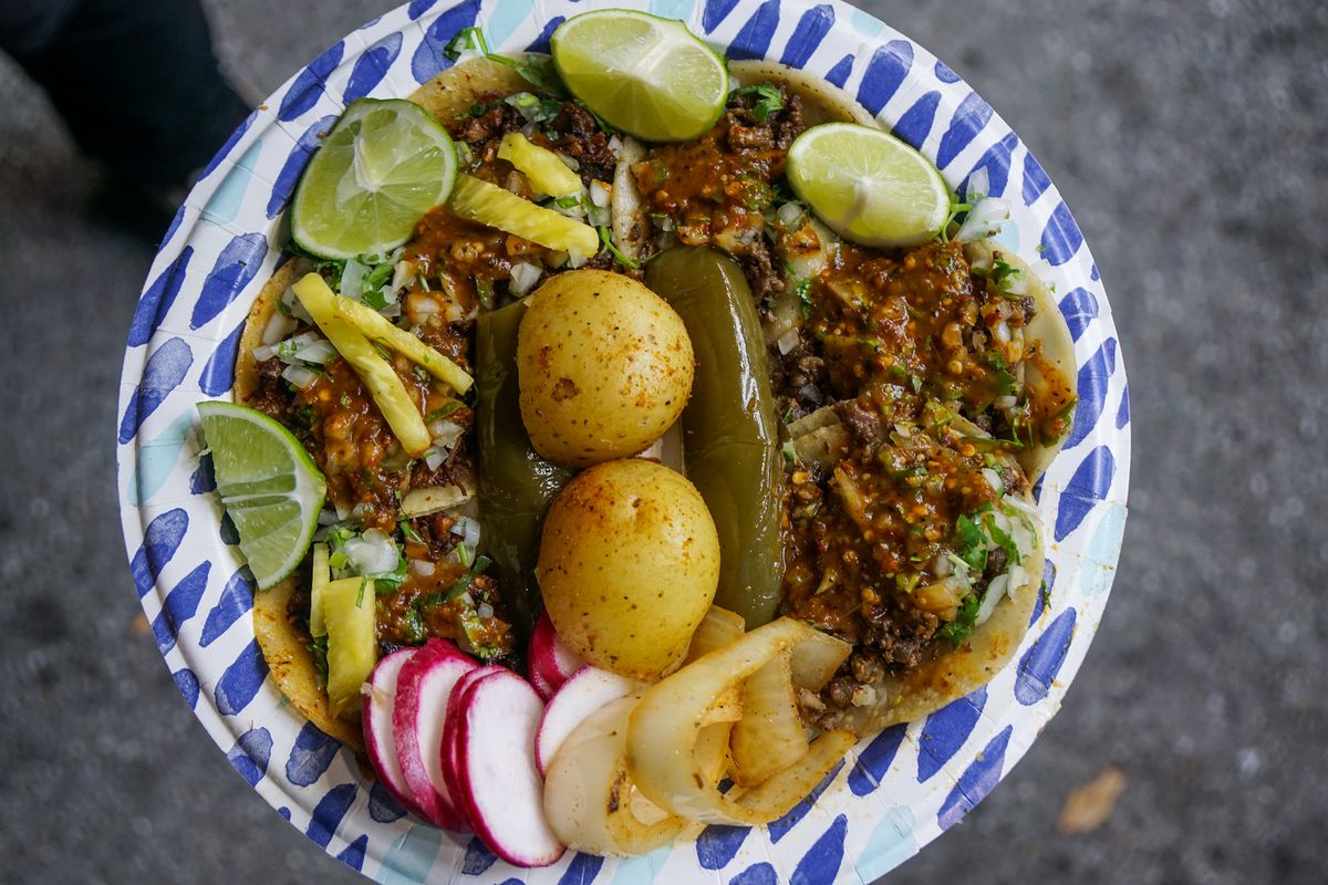 A taco plate with salsas, potatoes, radishes, and limes from El Chato Taco Truck in Los Angeles.