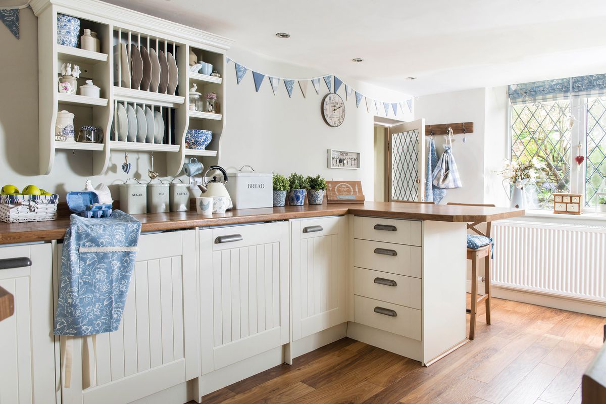 An off-white country kitchen with bedboard cabinets.
