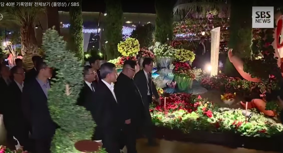 Kim Jong Un looking at flowers at a botanical garden in Singapore.