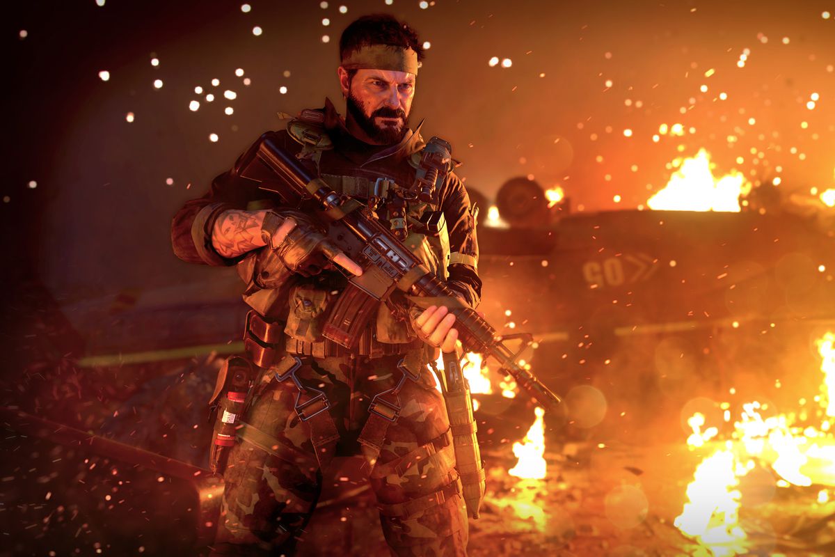 Woods stands in front of a fire in Black Ops Cold War