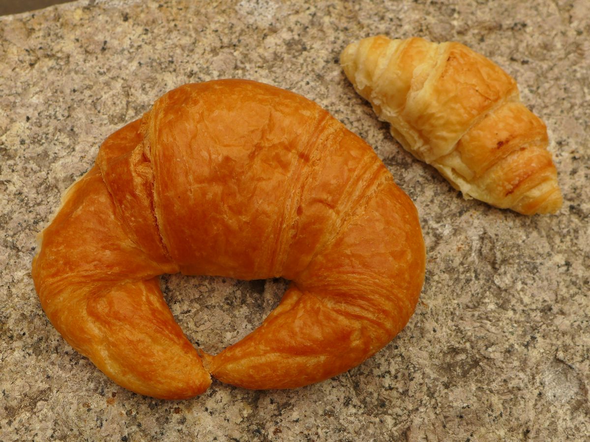 A regular and smaller croissant poised on a rock.