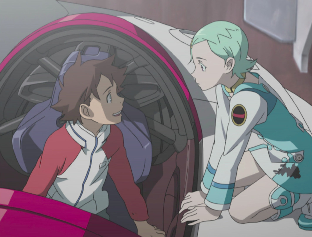 Charaters from Eureka Seven — Renton sits in the cockpit of the Nirvash unit smiling up at Eureka, who is kneeling on the outside of the unit.