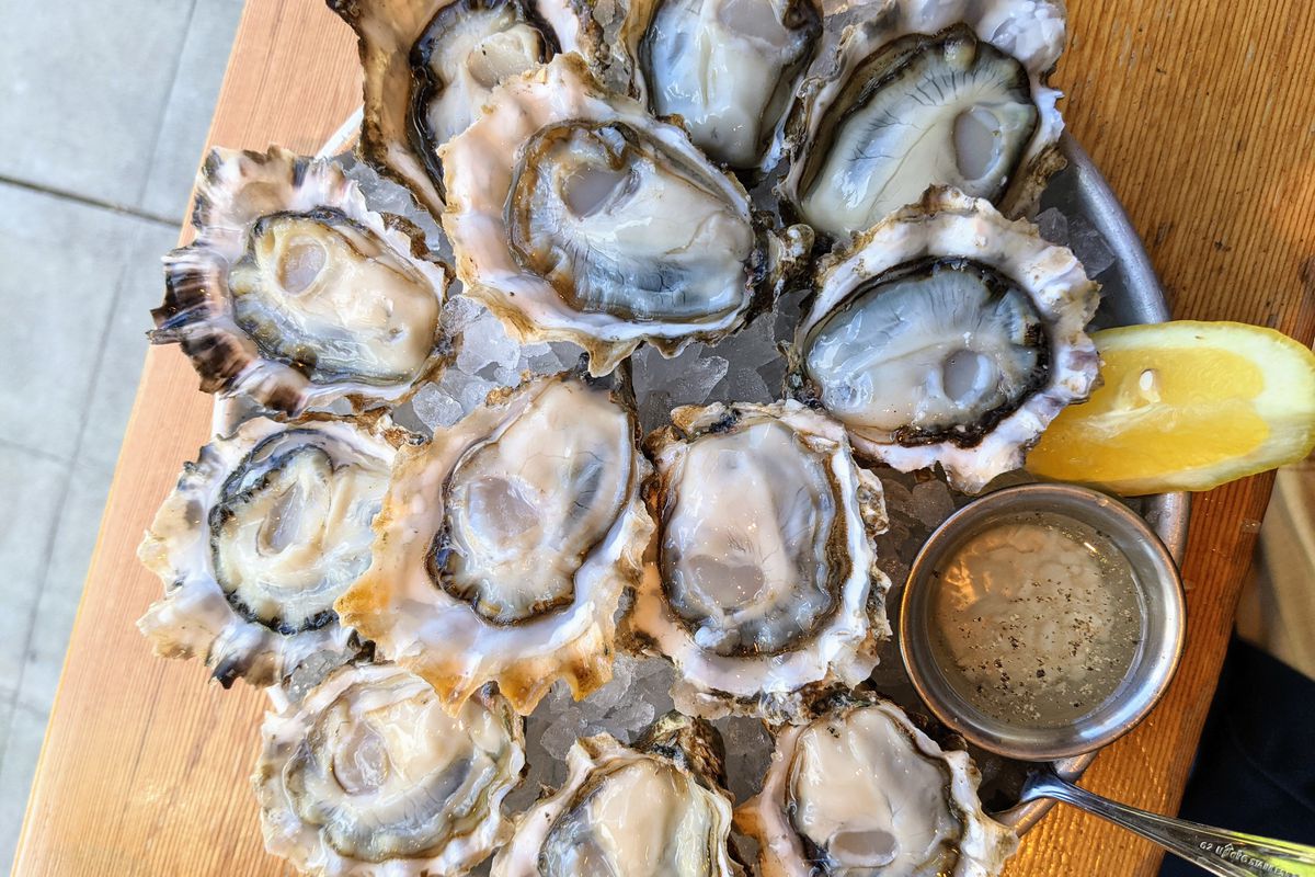 Raw oysters with mignonette sauce and lemon over ice.