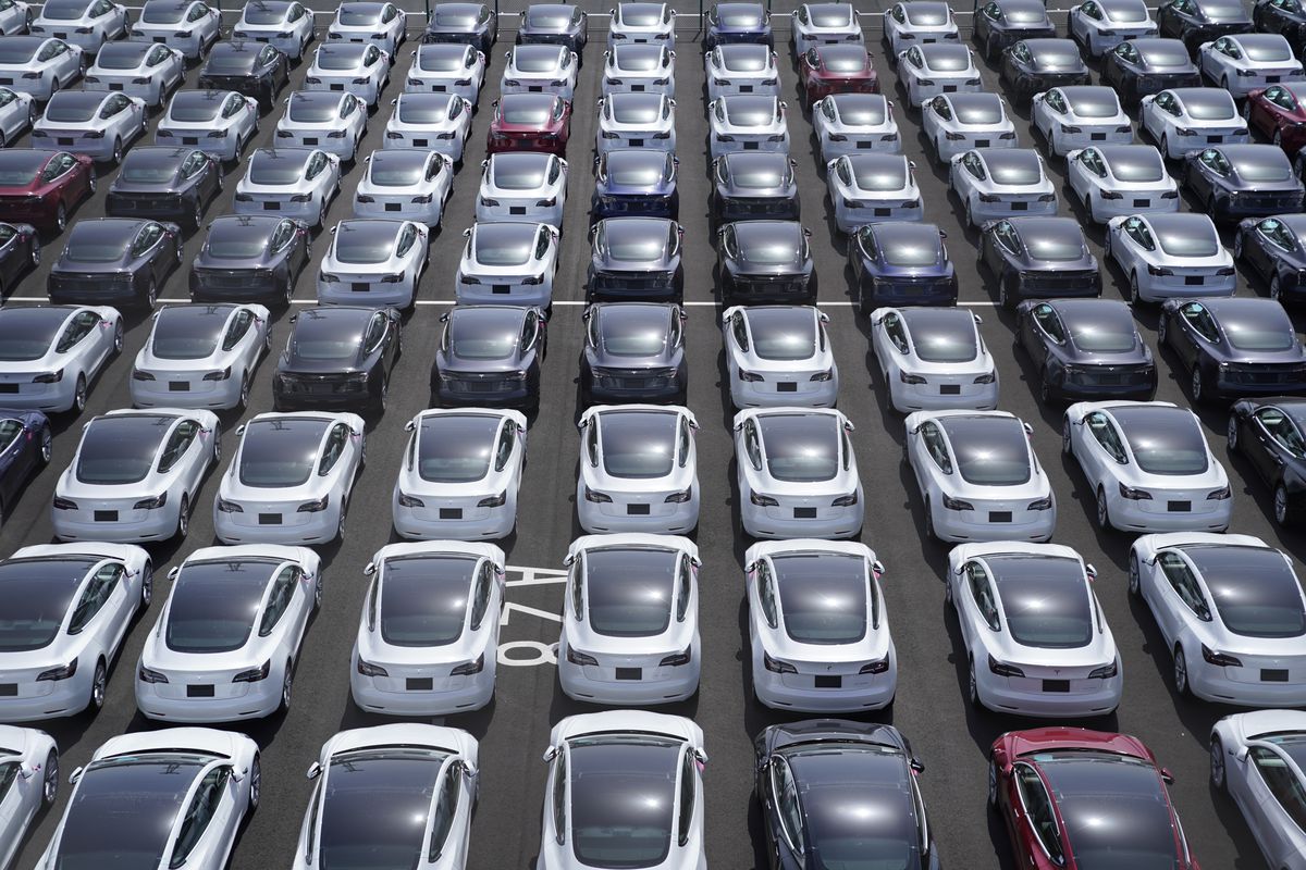 A parking lot full of Tesla automobiles.