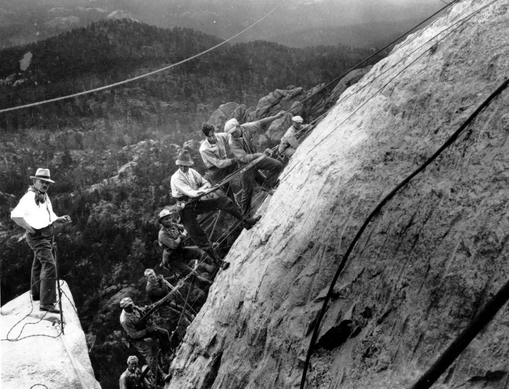 In this July, 22, 1929, file photo, sculptor Gutzon Borglum ( left) directs drillers suspended by cables from the top of the mountain as they work on the head of President George Washington at the Mount Rushmore Memorial in the Black Hills area near Keyst