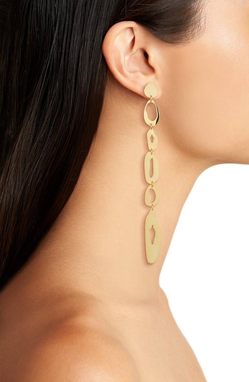 A model wearing dangly gold earrings