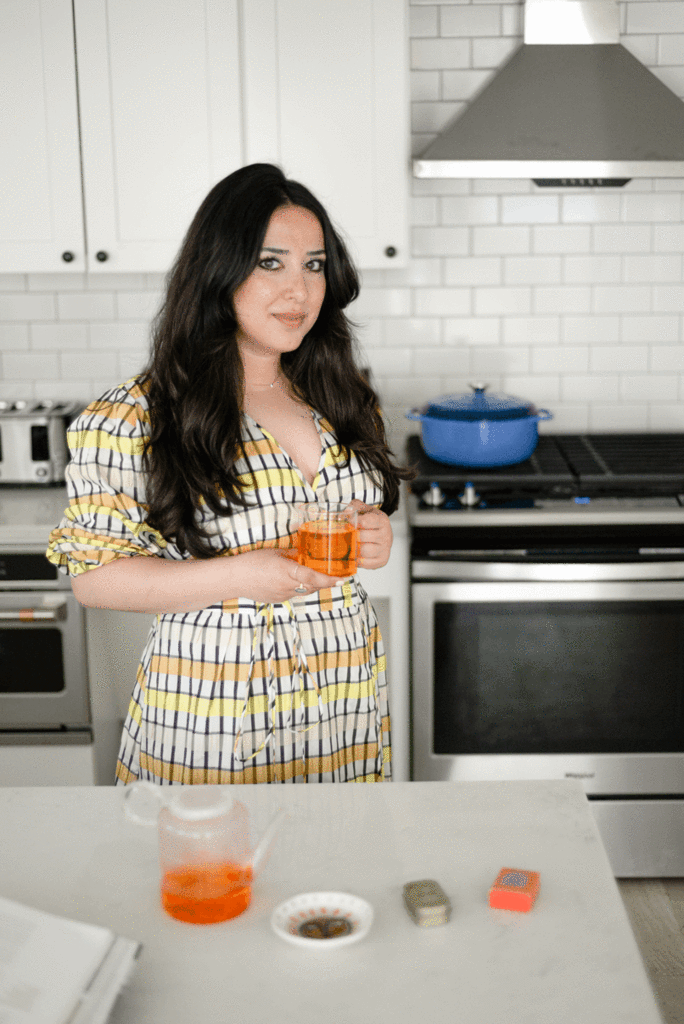Tahmina Ghaffer poses for a portrait with a glass of saffron tea.