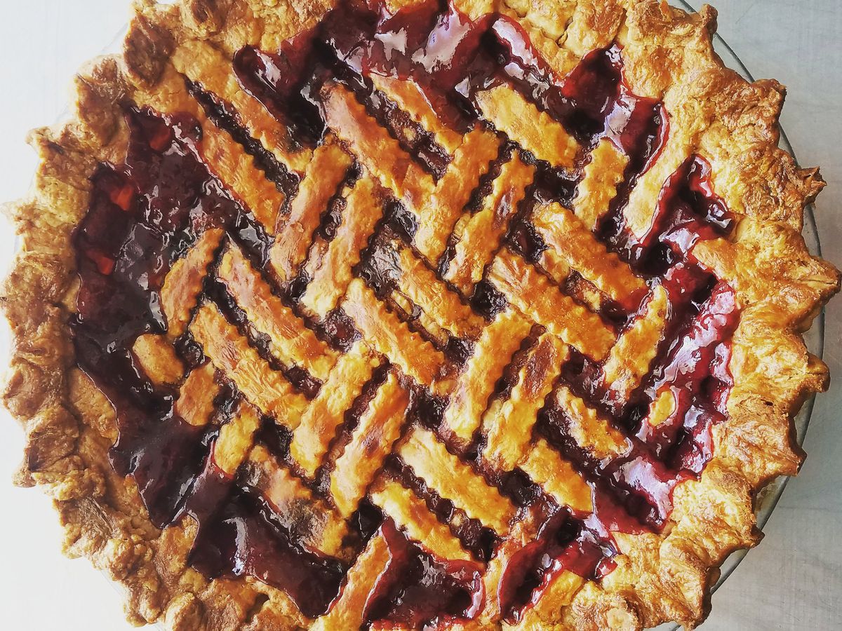 A berry pie with intricate latticed crust. 