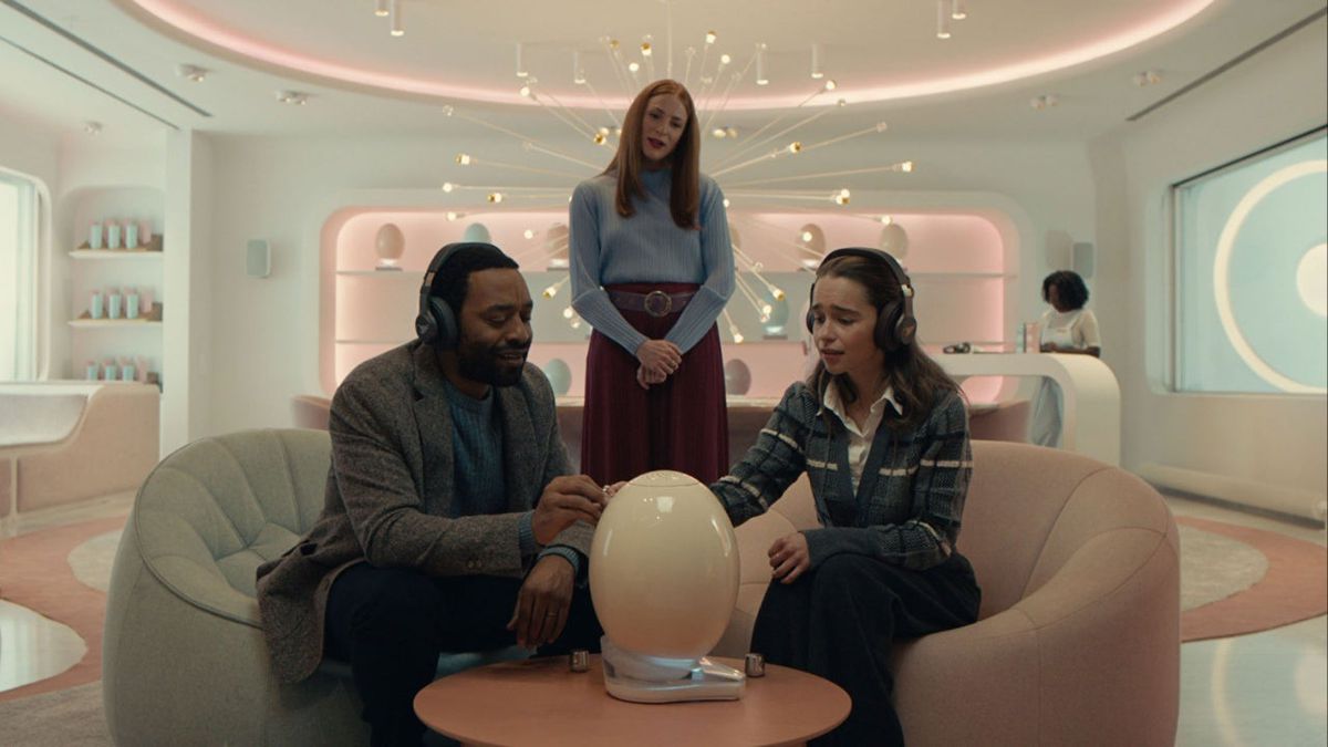 (L-R) Chiwetel Ejiofor, Rosalie Craig, and Emilia Clarke seated around a small egg-like device in The Pod Generation.