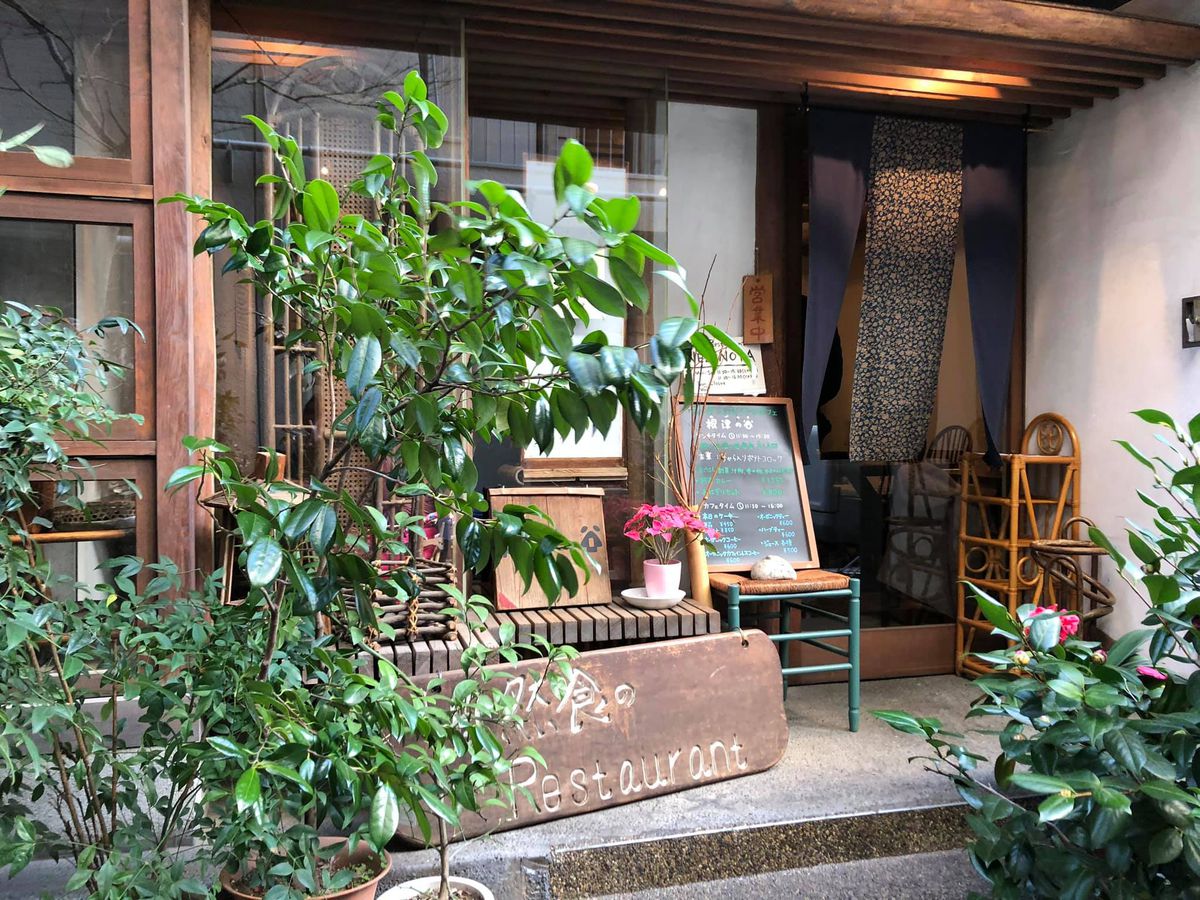 A restaurant exterior covered with potted plants.