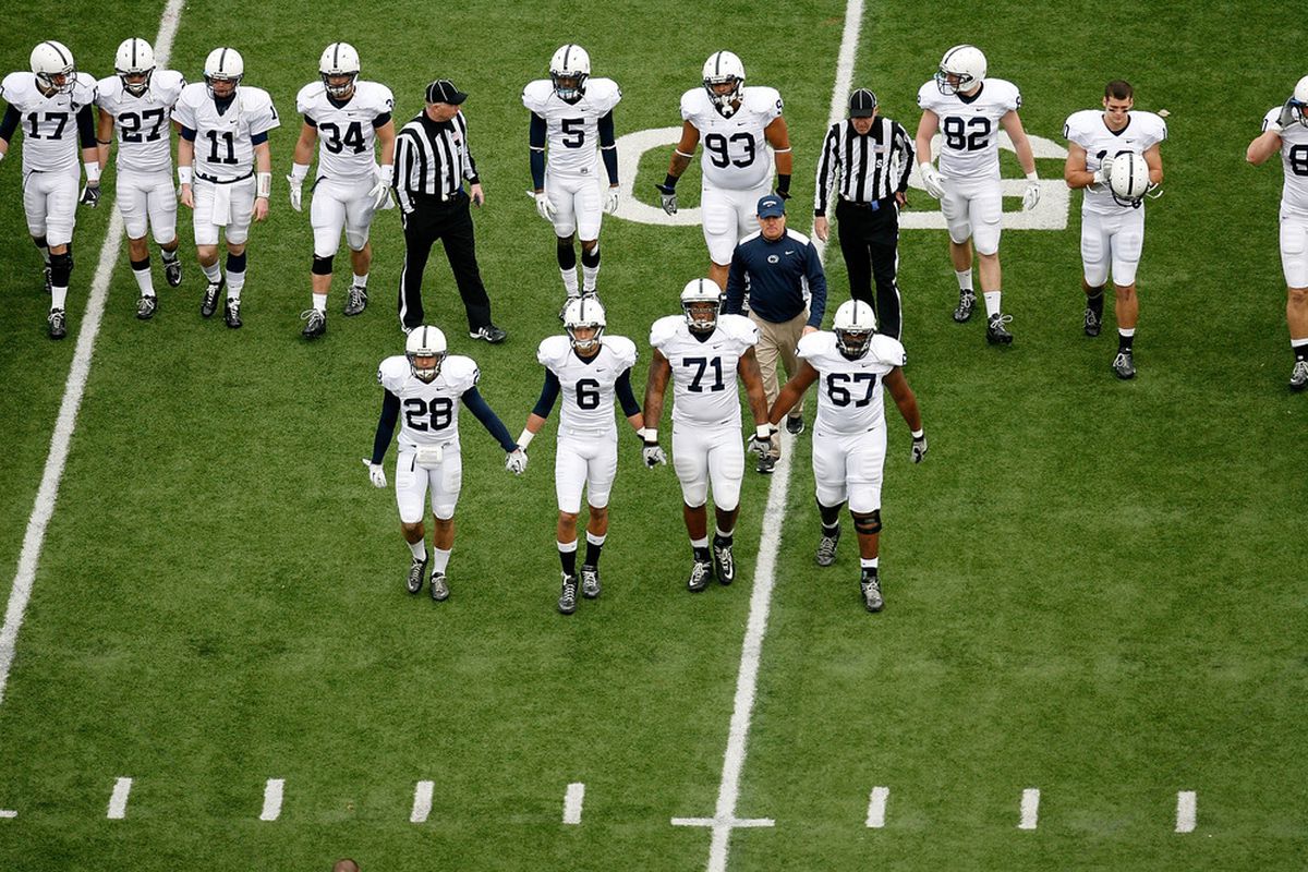 Drew Astorino #28, Derek Moye #6, Devon Still #71, and Quinn Barham #67, all of the Penn State Nittany Lions lead their teammates onto the field for the coin toss prior to the start of the game against the Ohio State Buckeyes on November 19, 2011.