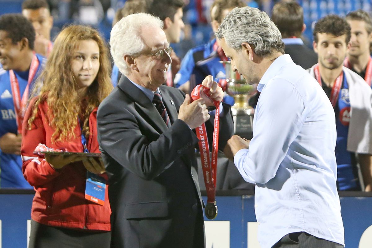 Not cool; a reminder - Frank Klopas accepts a winner's medal to the 2014 Voyageurs Cup, where Montreal vanquished Toronto FC