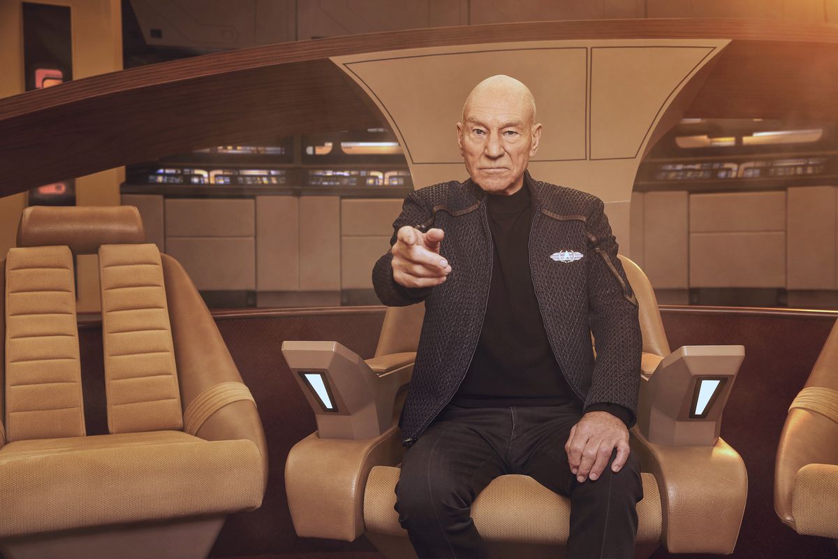 Patrick Stewart as Jean Luc Picard, sitting in his captain’s chair and making his classic “engage” gesture, in Picard. 