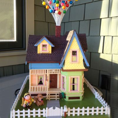 Gingerbread house replica of the home from the movie up complete with the boy and dog sitting outside in the yard.