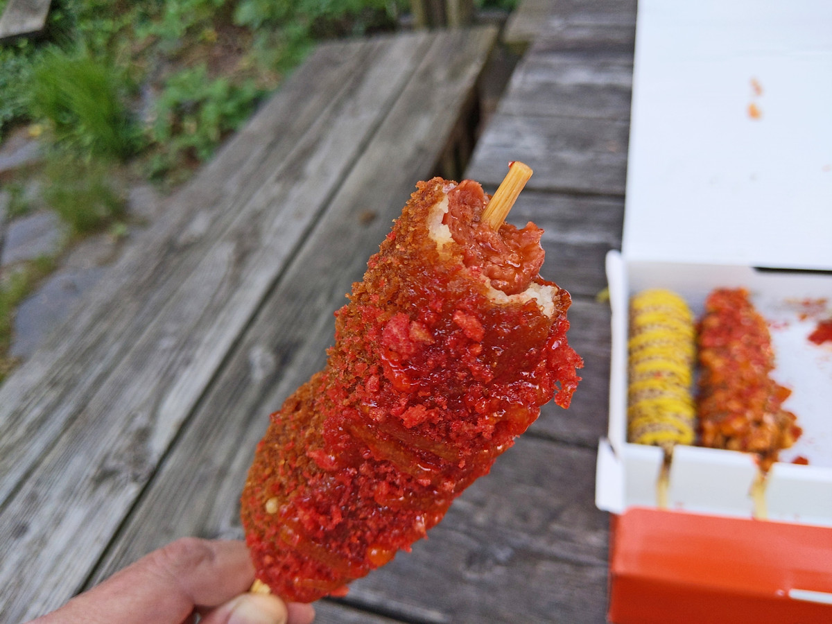A half-bitten, Hot Cheetos-encrusted Korean corn dog