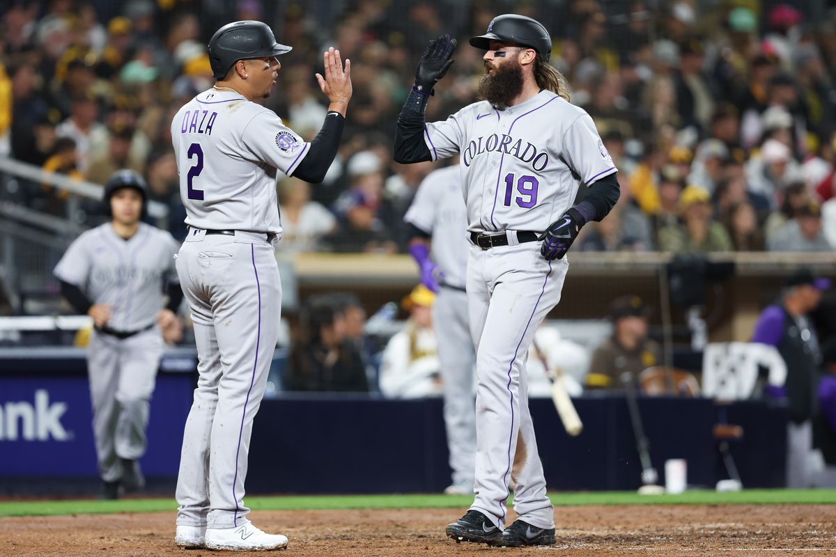 Yonathan Daza and Charlie Blackmon of the Colorado Rockies high-five after scoring in the fifth inning during the game between the Colorado Rockies and the San Diego Padres at Petco Park on Thursday, March 30, 2023 in San Diego, California.