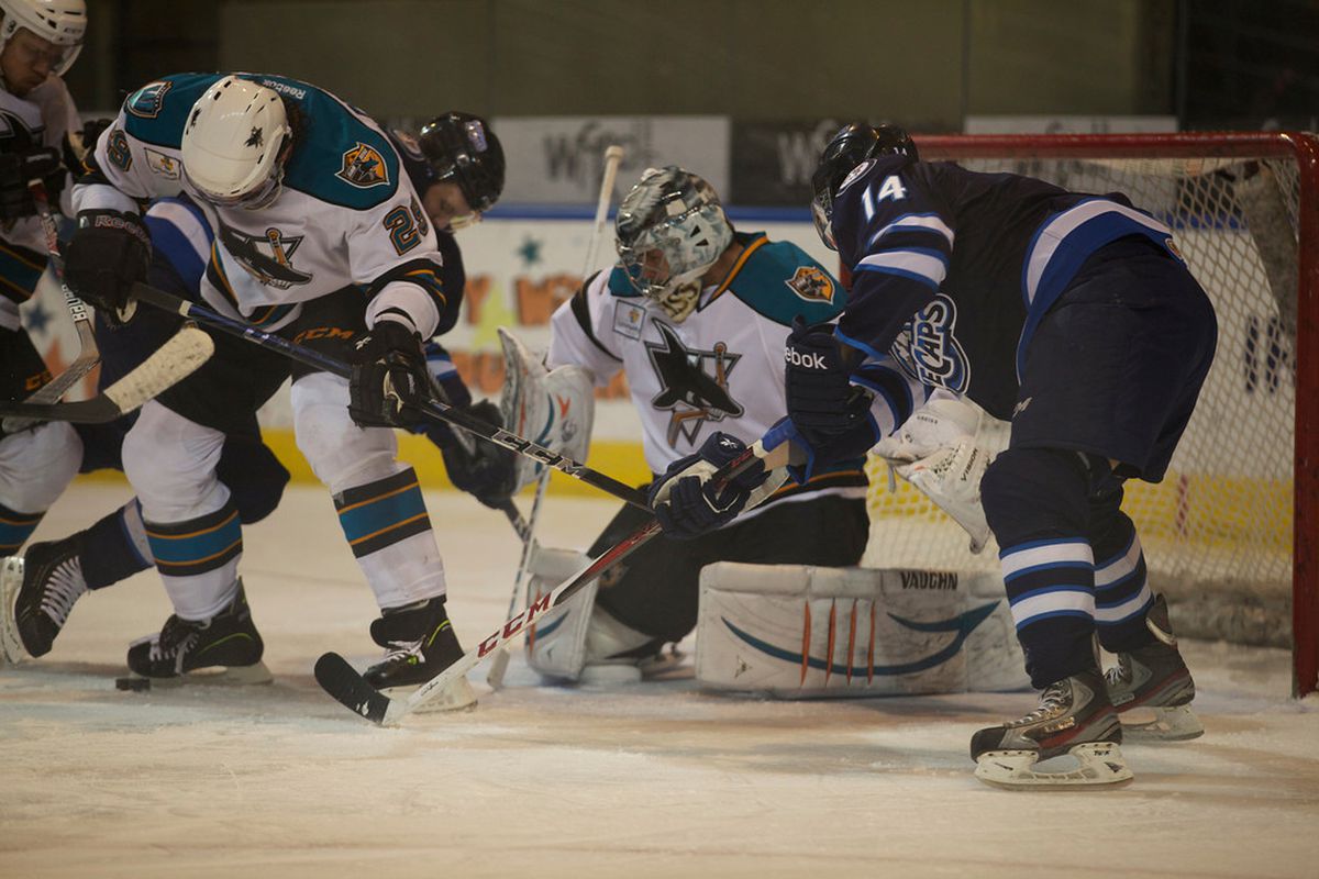 A scramble for the puck ensues in front of Worcester Sharks goaltender Thomas Greiss Saturday night at the DCU Center.