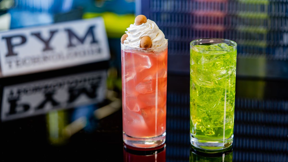 Two bright beverages in highball glasses, one topped with whipped cream and little snacks