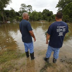 Mario Ureste and Richard Cisnero look over flooding during Tropical Storm Harvey in Houston on Wednesday, Aug. 30, 2017.