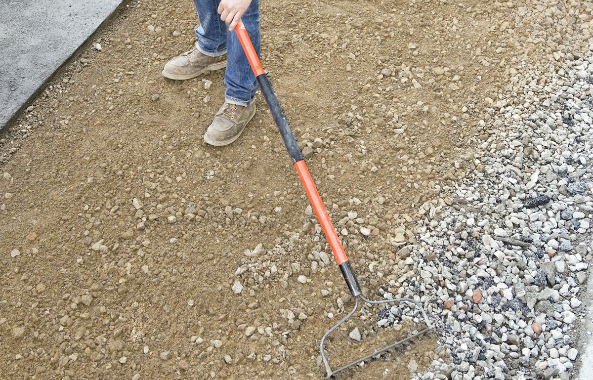 Man Levels Sand With Bow Rake For Driveway Apron
