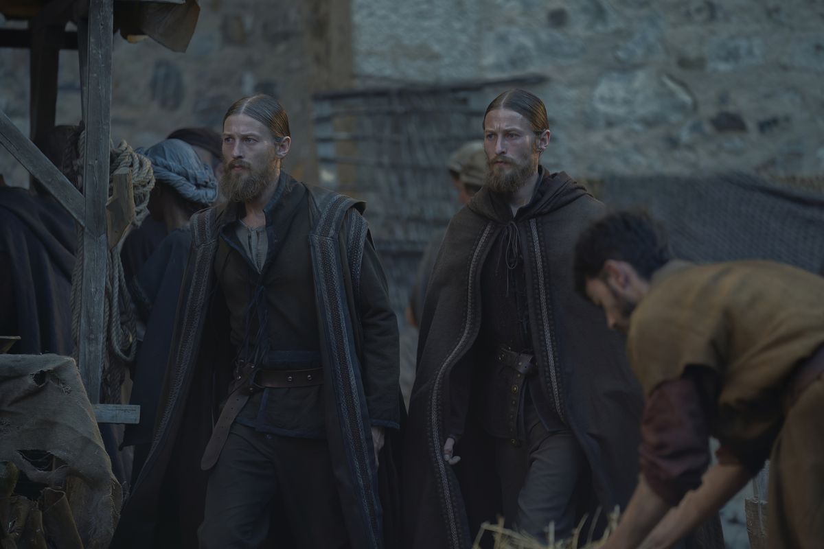 Twin brothers with middle parts and full beards walk next to each other in House of the Dragon.
