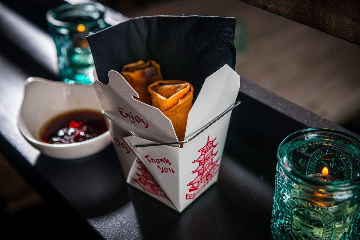 Veggie eggrolls come in a takeout box at Bar Chinois