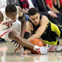 Arizona guard Justin Coleman, left, and Oregon’s Will Richardson, right, fight for a loose ball during the Arizona-Oregon game in McKale Center on January 17 in Tucson, Ariz.