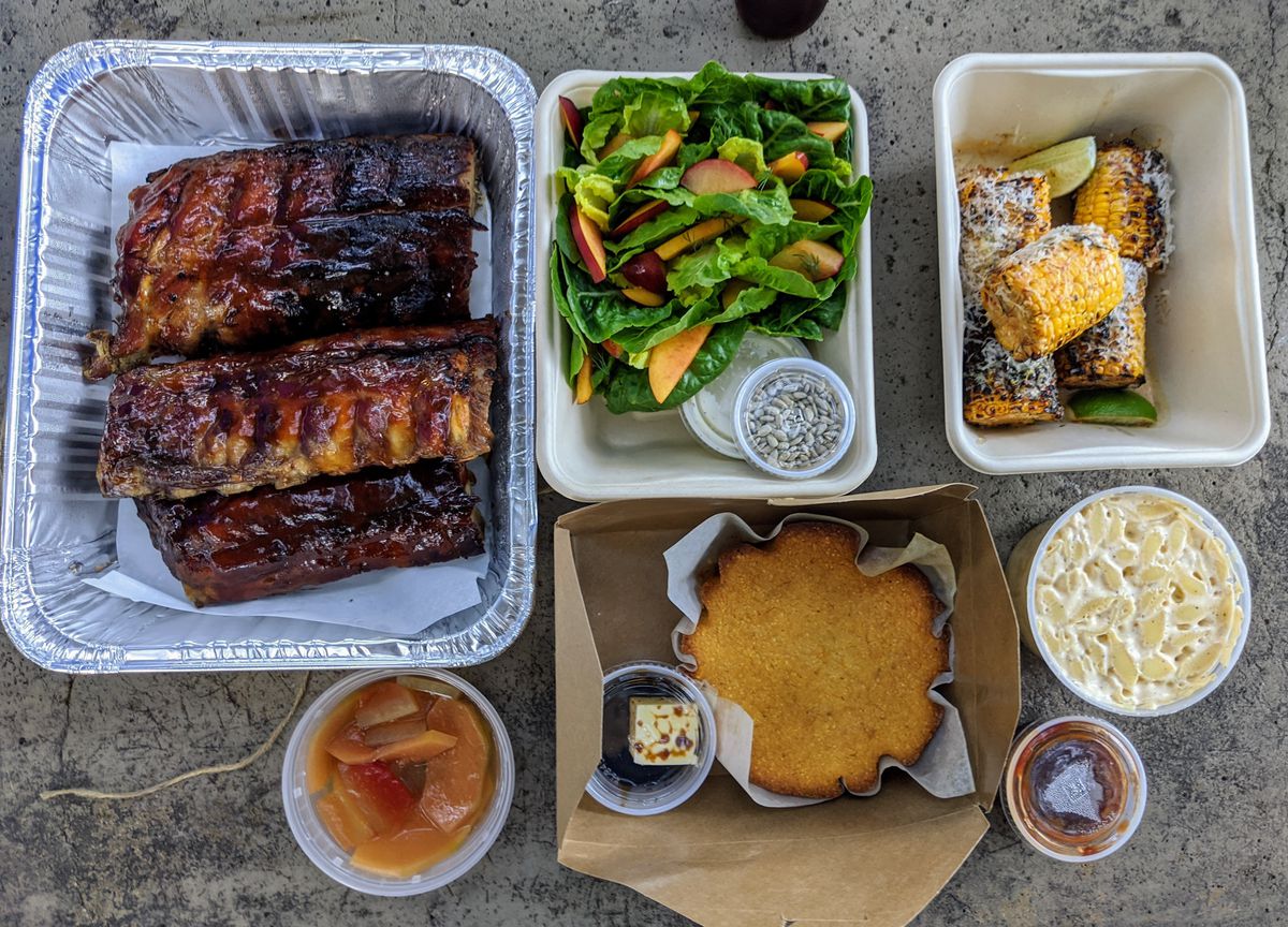 A spread of barbecue dishes including corn bread, ribs, corn, and mac and cheese.